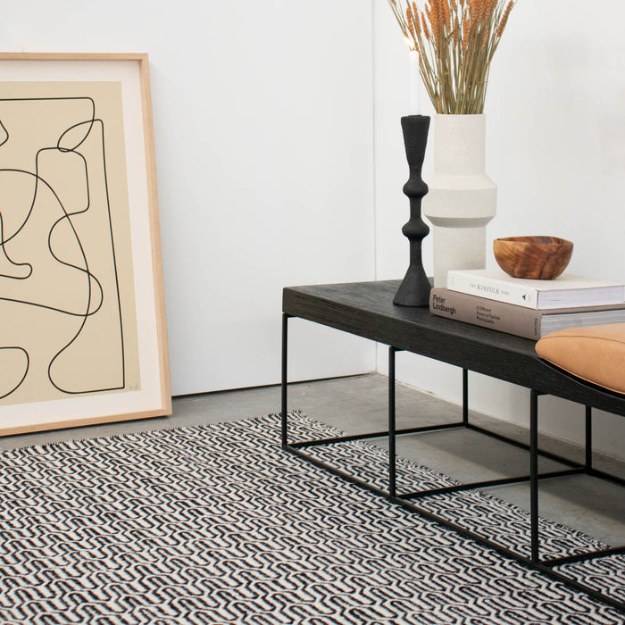 Zwart Wit Tapijt Helder gecombineerd met meerdere meubels in een woonkamer.ALT